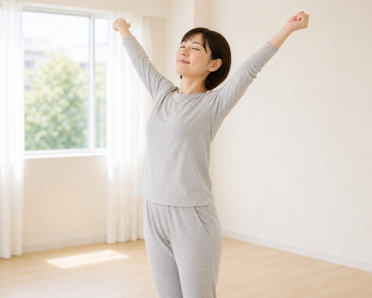 朝の光の中で両腕を広げて伸びをする女性